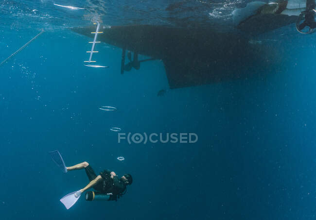 Immersionista in avvicinamento barca subacquea presso la grande barriera corallina — Foto stock