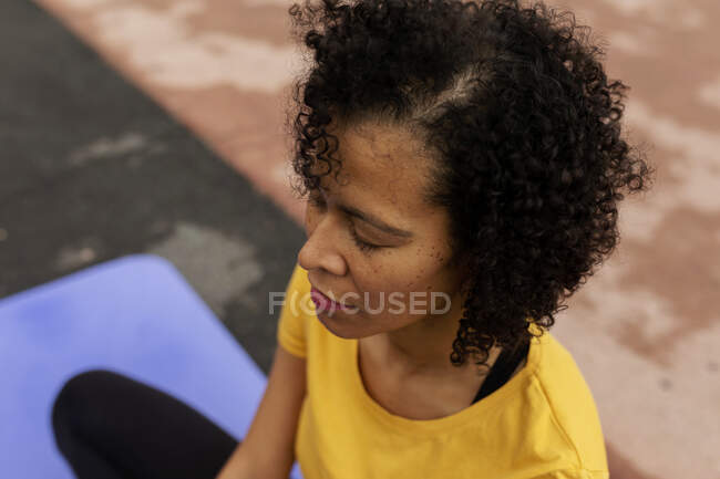 Donna latina tranquilla seduta sul pavimento che pratica yoga — Foto stock
