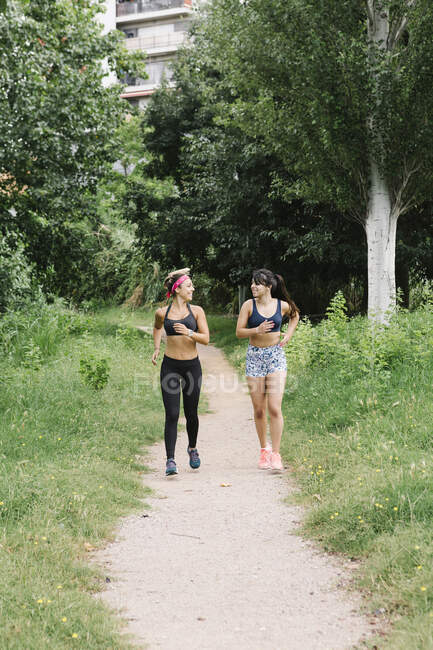 Due donne fanno jogging sul marciapiede rurale — Foto stock
