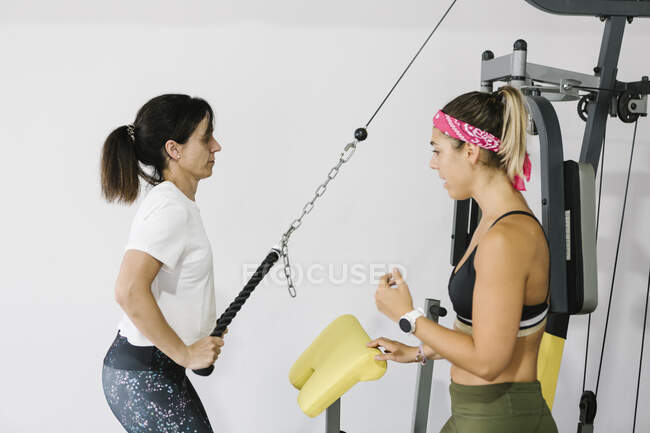 Зріла жінка тренується зі своїм особистим тренером у спортзалі — стокове фото