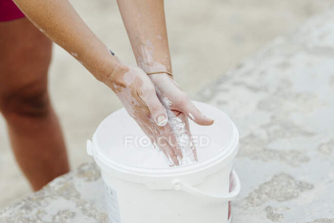 Woman putting chalk in her hands before practicing crossfit. — Stock Photo