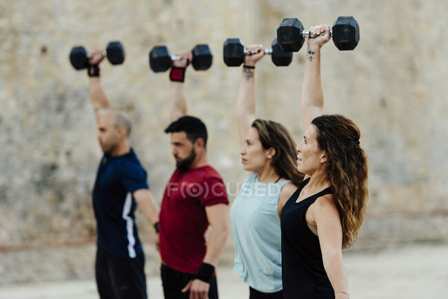 Athletes lifting a crossfit weights in an urban enviroment. — Stock Photo