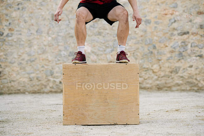 Uomo che pratica il crossfit saltando in una scatola piometrica. — Foto stock