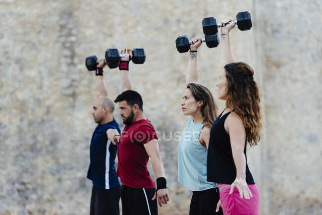 Sportler stemmen Crossfit-Gewichte in urbaner Umgebung. — Stockfoto