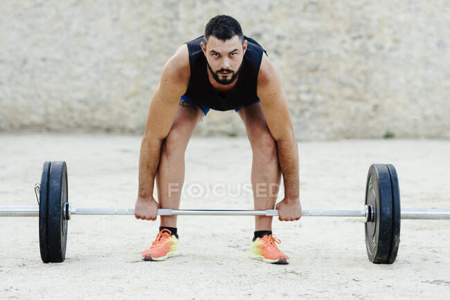 Weightlifter with beard lifting weights in an urban environment. — Stock Photo