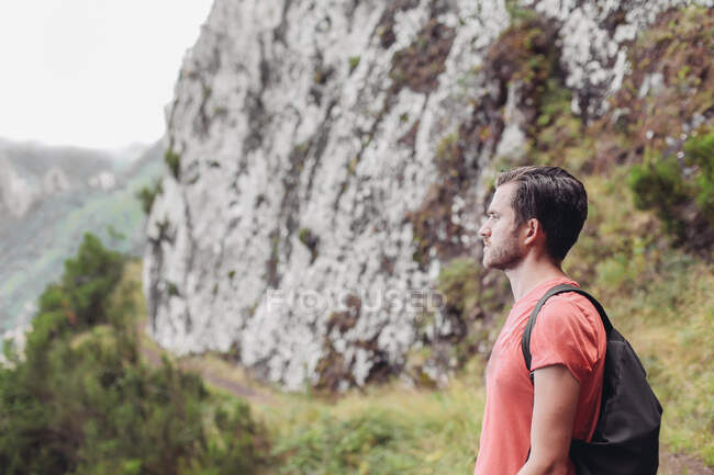 Un uomo con lo zaino escursionismo in montagna — Foto stock