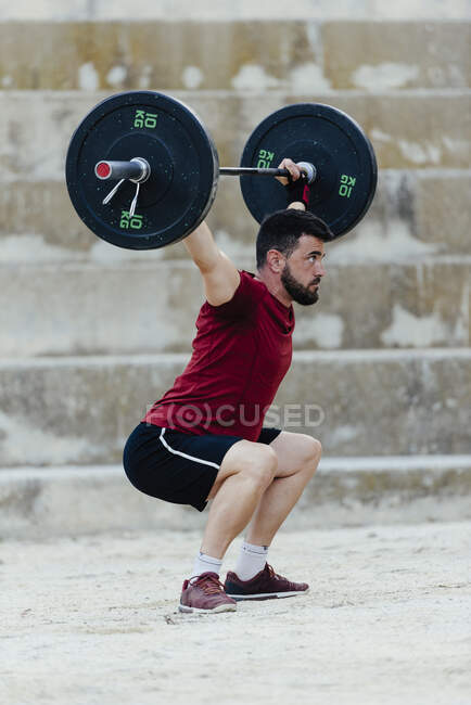 Weightlifter lifting weights in an urban environment. — Stock Photo