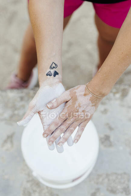 Frau steckt sich Kreide in die Hände, bevor sie Crossfit übt. — Stockfoto