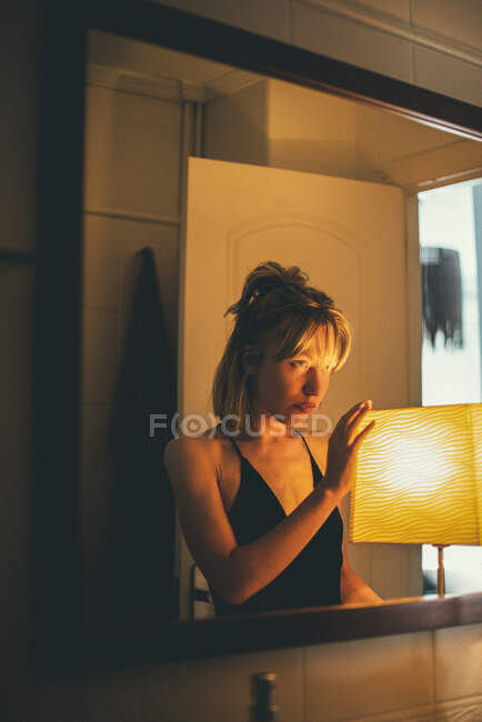 Porträt einer niedlichen kaukasischen Frau beleuchtet mit einer warmen Lampe. — Stockfoto