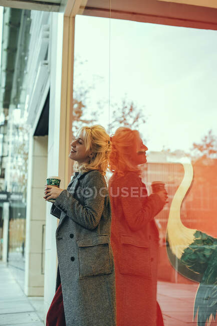 Portrait of a stylish caucasian woman holding a cup of coffee. — Stock Photo