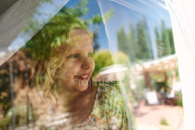 Mädchen in einem Wohnwagen auf einem Campingplatz. Sie blickt aus dem Fenster. — Stockfoto