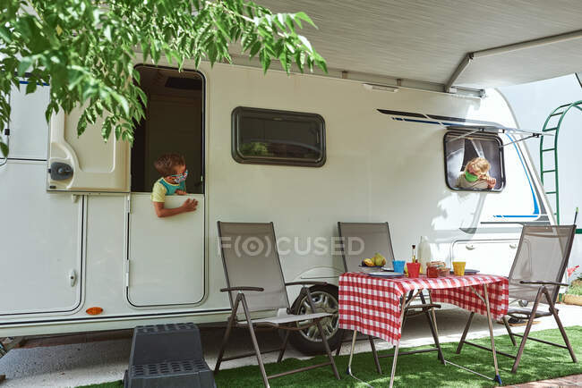 Brothers on vacation in a caravan. They have a face mask for corona virus. — Stock Photo