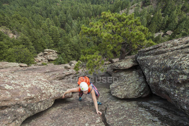 Женщина взбирается на Второй Флатирон без веревки над Боулдером, Колорадо — стоковое фото