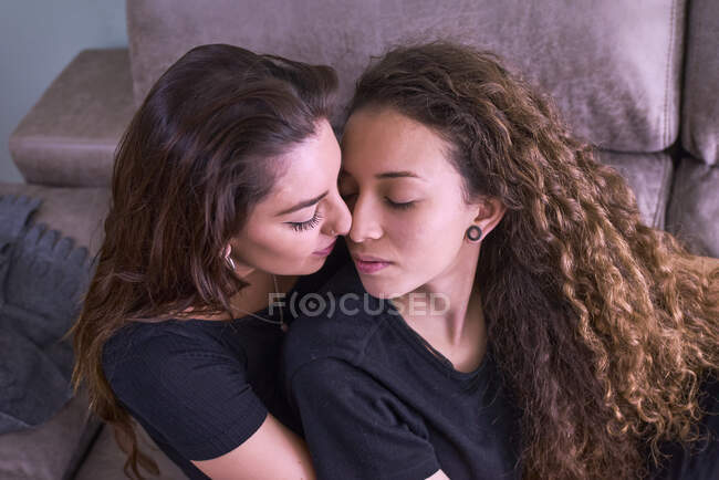 Echt lesben küssen auf die couch bei zuhause — Stockfoto