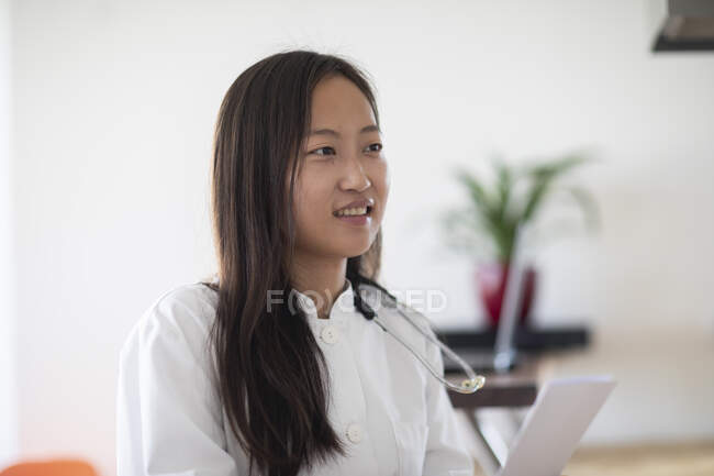 Молода азіатська жінка-лікар зі звітом на практиці — стокове фото