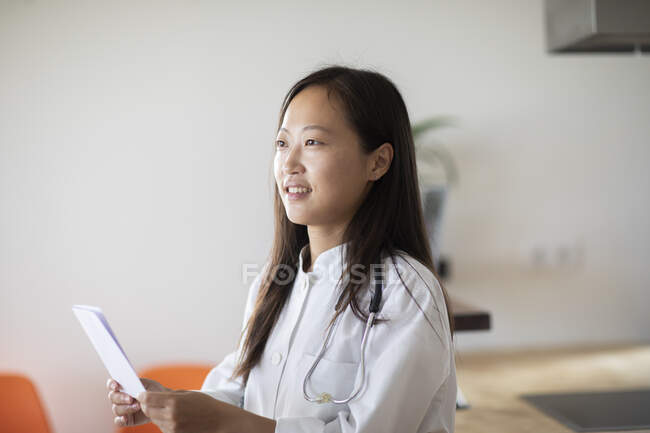 Joven asiático mujer médico con informe en un práctica - foto de stock