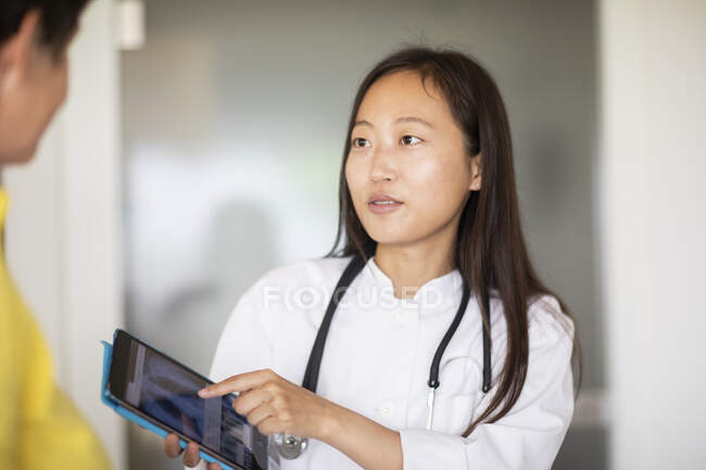 Junge asiatische Ärztin Frau und Patientin mit Bericht in einer Praxis — Stockfoto