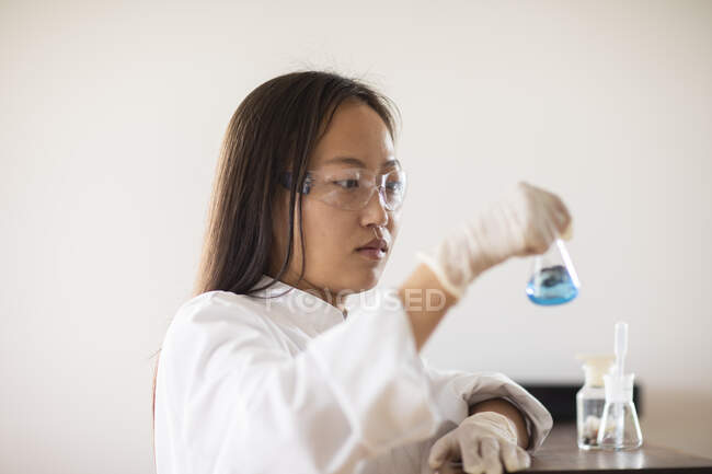 Scientifique femelle avec échantillon et tubes dans un laboratoire — Photo de stock