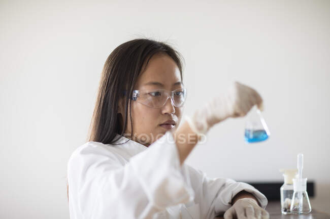 Cientista fêmea com amostra e tubos em um laboratório — Fotografia de Stock