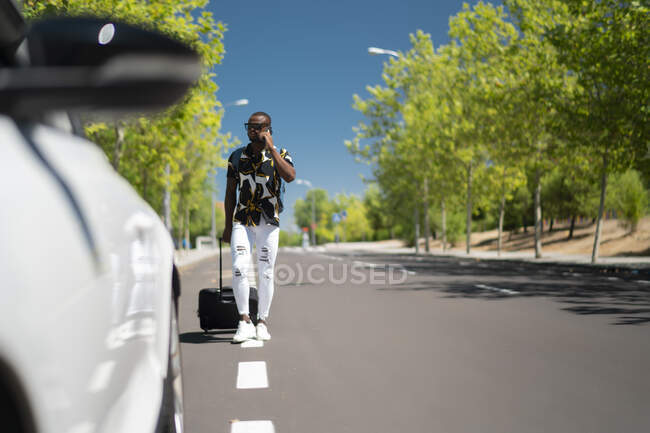Молодой африканский мужчина разговаривает по телефону, чтобы отправиться в путешествие — стоковое фото