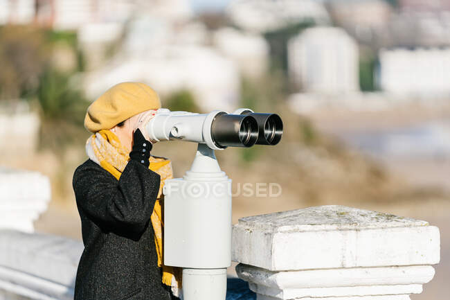 Mulher em férias olhando através de binóculos — Fotografia de Stock