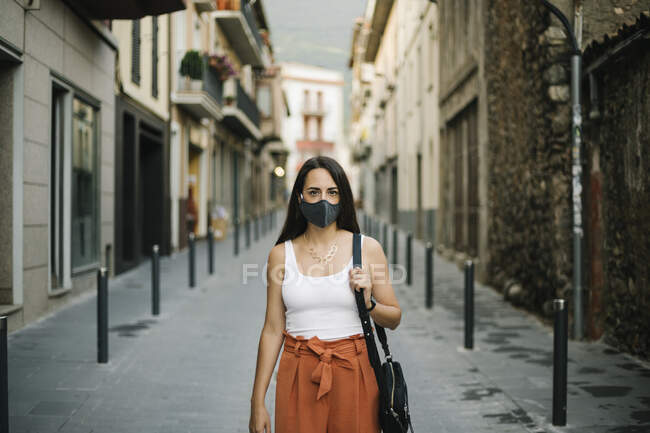 Mujer con mascarilla en la ciudad - foto de stock