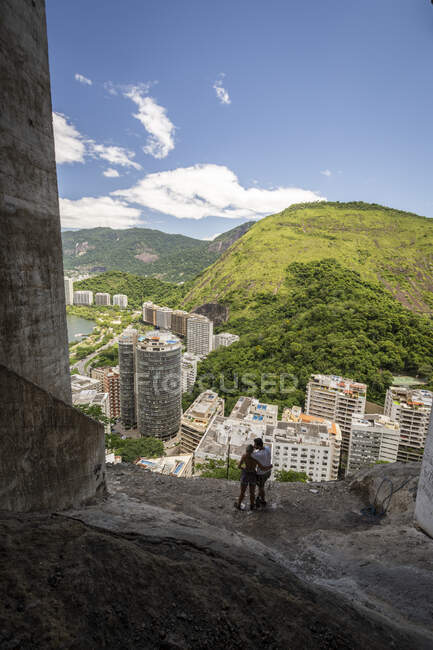 Vista sulla coppia di arrampicatori sul bordo della montagna sul paesaggio verde — Foto stock