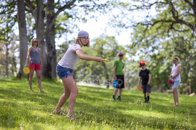 A young girl plays frisbee golf at a course in The Dalles, Oregon. — Stock Photo