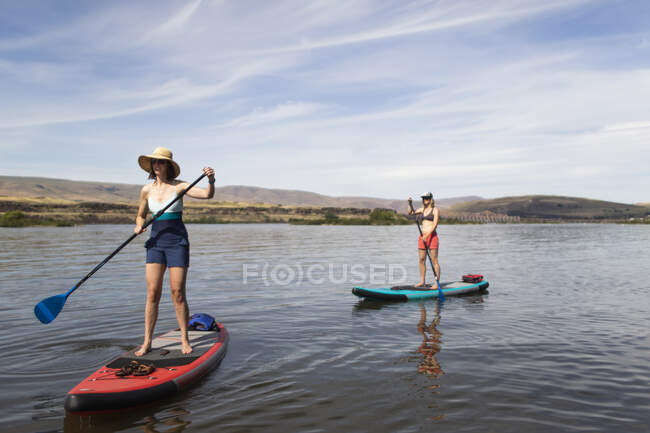 Duas amigas desfrutam de seus SUPs no rio Columbia, no Oregon. — Fotografia de Stock
