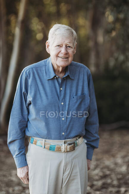 Ritratto di uomo adulto anziano sorridente nella foresta — Foto stock
