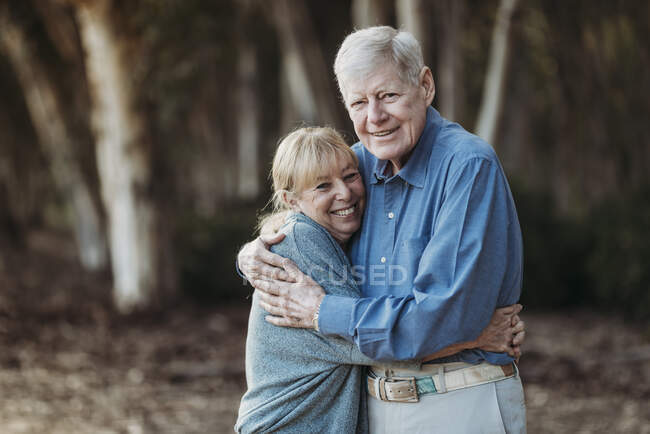 Retrato de pareja de adultos jubilados abrazándose en el bosque —  vinculación, personas de edad avanzada - Stock Photo | #422076126