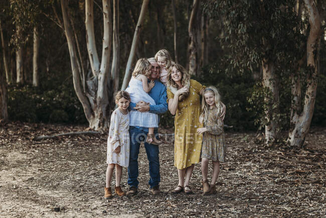 Retrato de familia extendida grande abrazando fuera - foto de stock