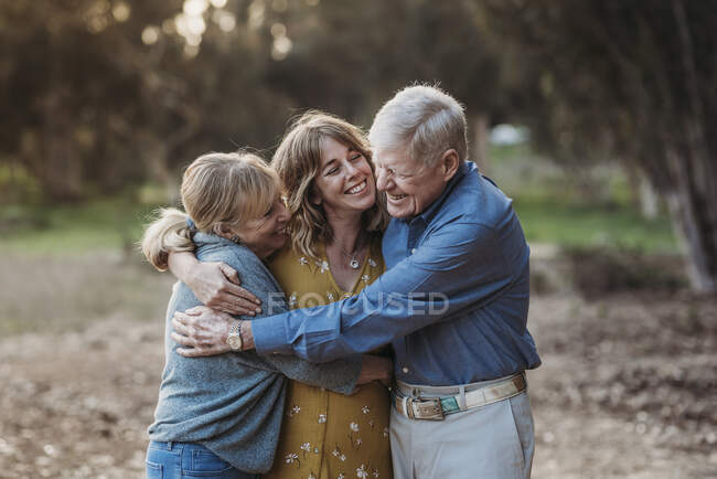 Porträt einer erwachsenen Frau und Senioren, die sich im Park umarmen — Stockfoto