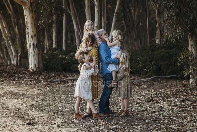 Портрет молодой семьи, обнимающейся на улице — стоковое фото