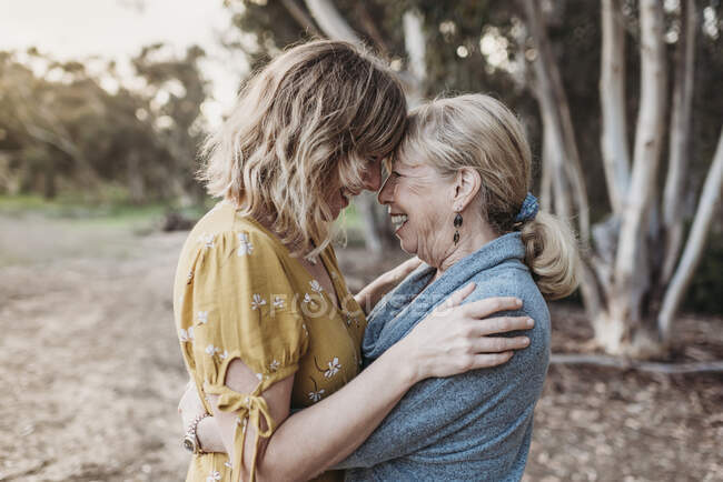 Lifestyle portrait of adult mother and senior mother smiling — Stock Photo