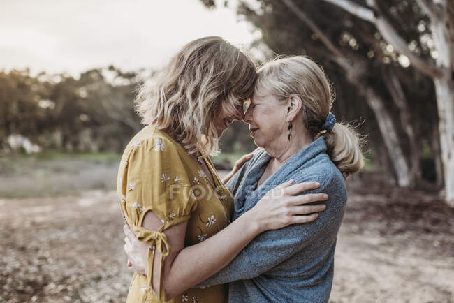 Lifestyle portrait of adult mother and senior mother embracing — Stock Photo