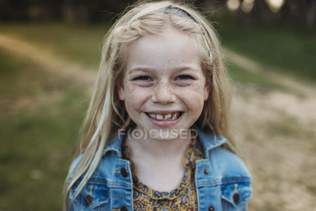 Close up retrato de escola idade menina sorrindo fora — Fotografia de Stock
