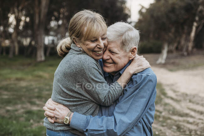 Primer retrato de pareja adulta mayor abrazándose en el bosque - foto de stock