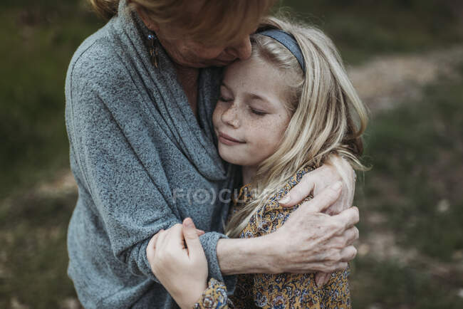 Grandmother and granddaughter smiling in field — Stock Photo
