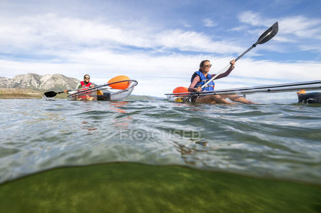 Kayakers disfrutando de una mañana de verano remando en Lake Tahoe, CA - foto de stock