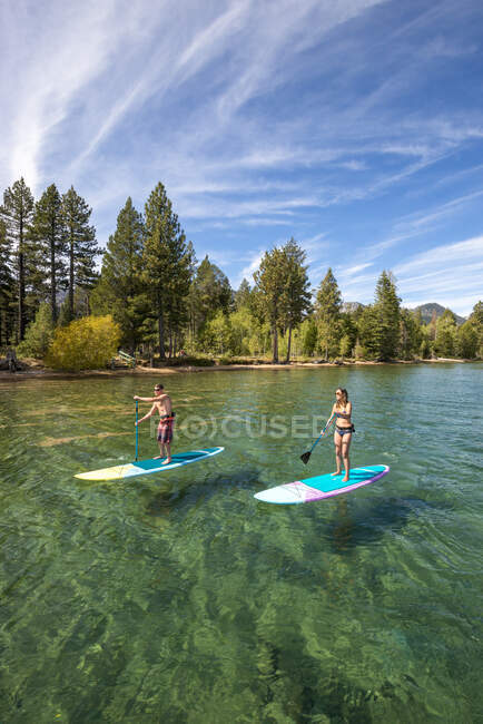 Мужчина и женщина встают на весло на озере Тахо, Калифорния — стоковое фото