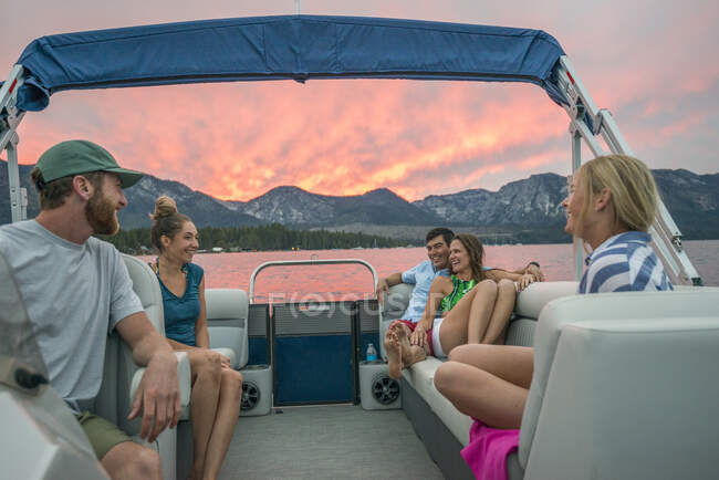 Un grupo de amigos navegando en el lago Tahoe al atardecer, CA - foto de stock