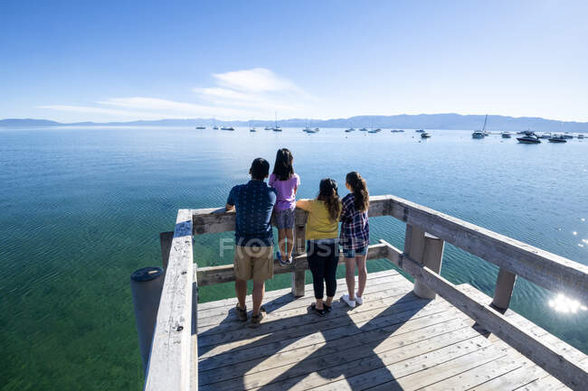 Uma família olha para as águas calmas do Lago Tahoe de um cais em um dia ensolarado de verão em South Lake Tahoe, Califórnia. — Fotografia de Stock