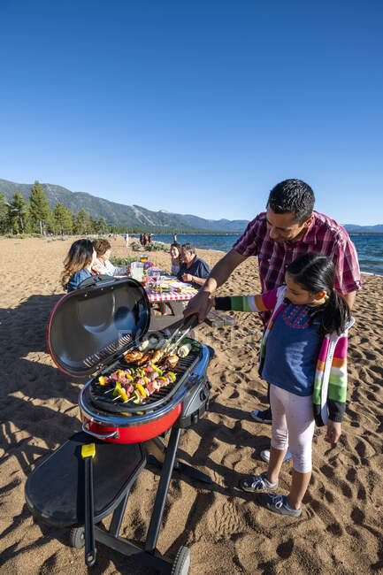 Una famiglia mulit-generazionale gode di un barbecue su una spiaggia nel lago Tahoe, Nevada. — Foto stock
