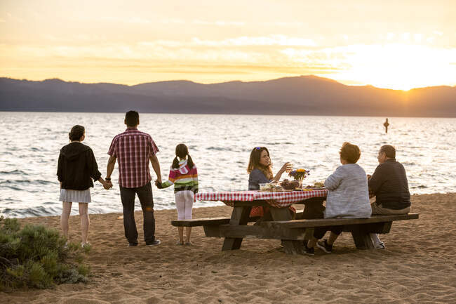 Una famiglia multigenerazionale si gode un picnic al tramonto sulla spiaggia del Nevada a Lake Tahoe, Nevada. — Foto stock