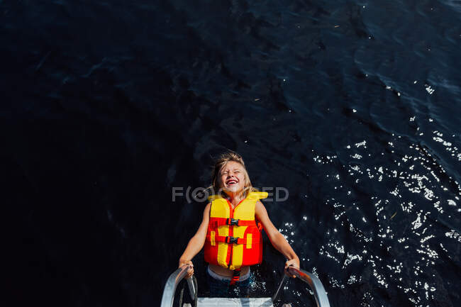 Giovane ragazzo sulla scala dock con enorme sorriso — Foto stock