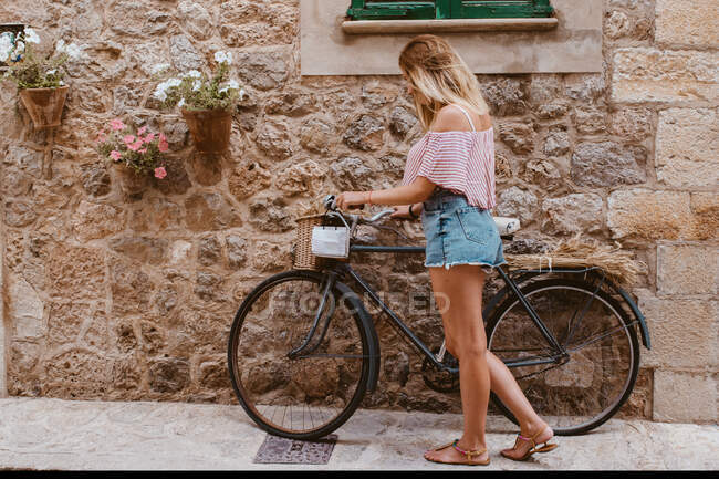 Bela jovem mulher com bicicleta na cidade — Fotografia de Stock