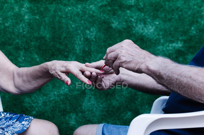 Close up of a senior couple holding hands together — Stock Photo