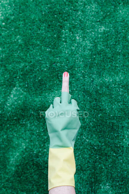 Main avec un gant en caoutchouc avec un fond vert — Photo de stock