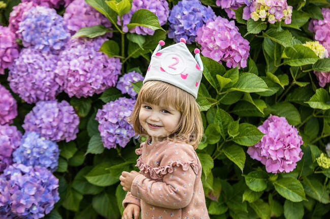 Menina sorridente bonita com uma coroa celebra seu aniversário — Fotografia de Stock